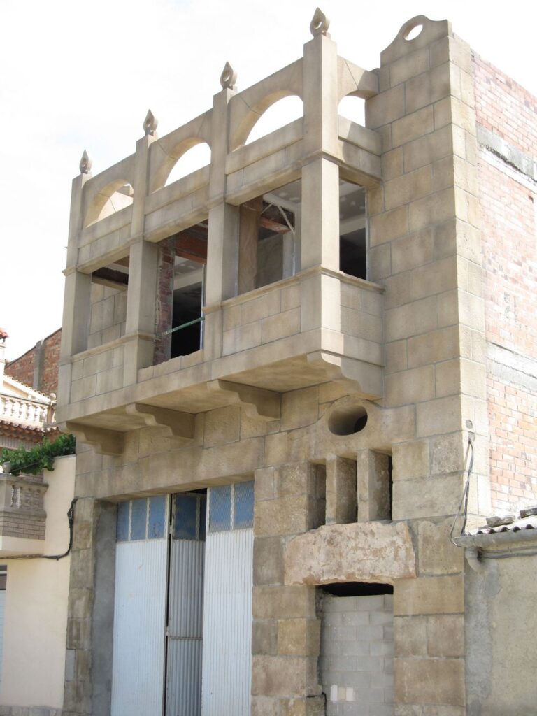 Fachada modernista de vivienda particular en Maials con muros decorativos de piedra artificial y mortero ESTonetex TXT