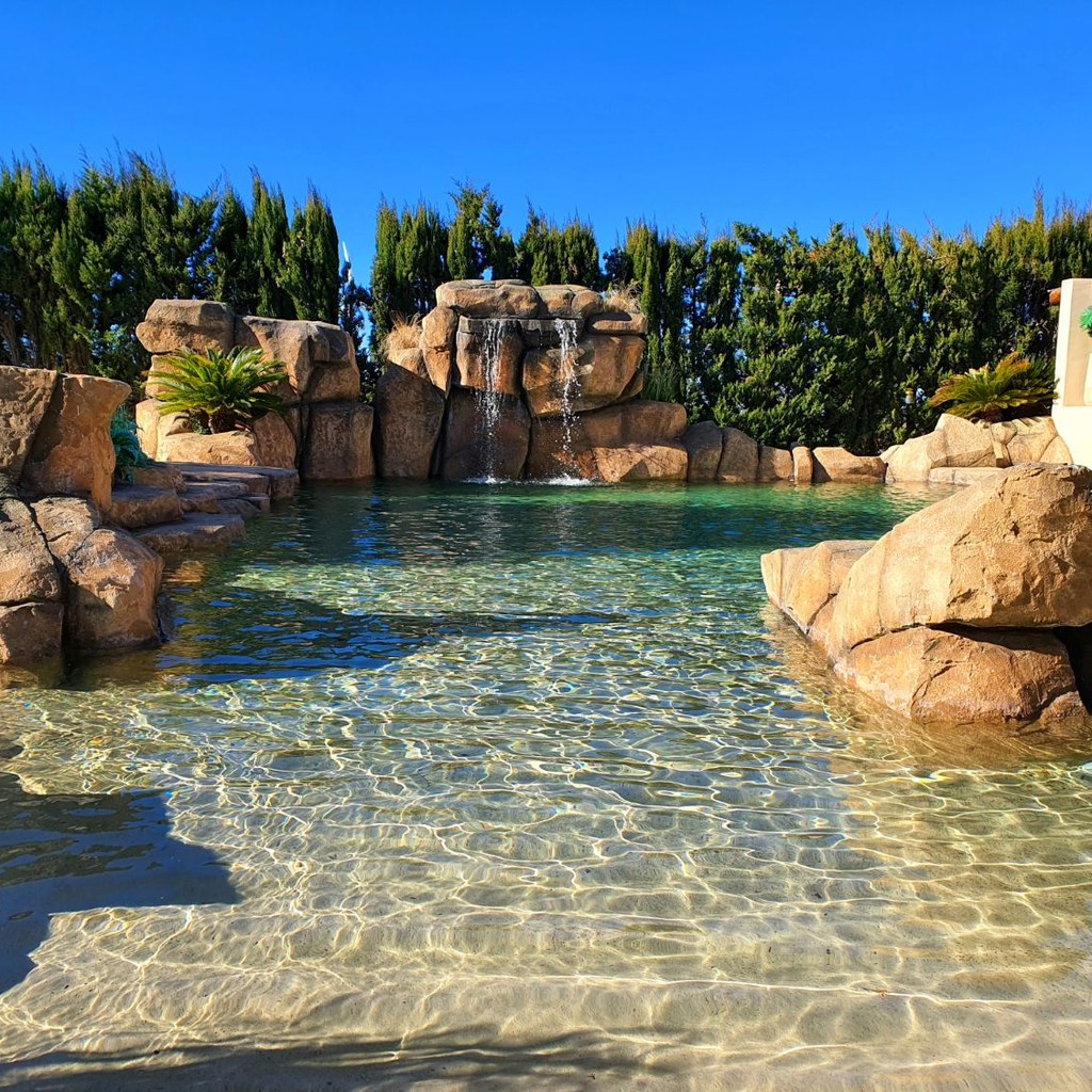 Cascada artificial de roca en piscina particular Piscina particular con cascada y rocas artificiales de mortero ESTonetex Sulfo, trabajo realizado por Aplidecor